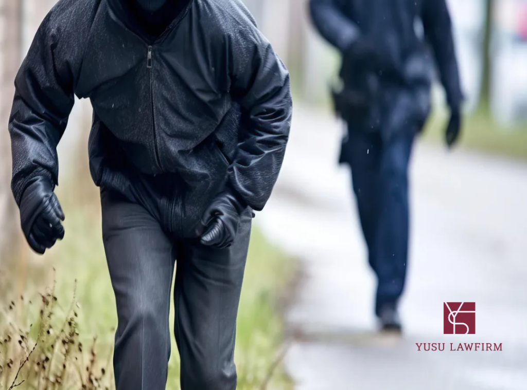 Two figures in dark clothing walking away — theft and criminal liability in Korea